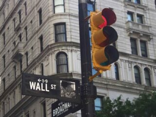 Street intersection showing signs for Wall Street and Broadway