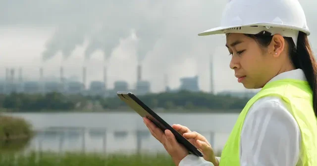 Engineer working and laptop at coal power plant.