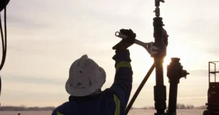 Oil field worker at sunrise